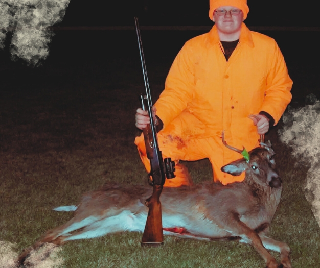 The hunter, seen in blazer orange, shows his whitetail buck harvested during Wisconsin rifle season.